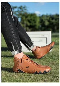 Close-up of brown leather high-top boots with LDECK ankle strap on grass