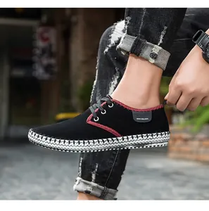 Detail of black suede casual shoe featuring red stitching and a thick white textured sole