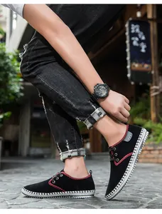 Close-up of black canvas men's sneakers with red stitching and woven sole detail