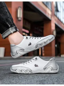 Détail d'une basket en cuir blanc et argent avec perforations latérales et semelle en caoutchouc