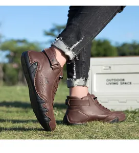 Detail view of the brown leather high-top boot featuring a textured surface and velcro strap