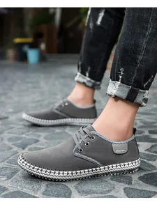 Detail of grey suede men's sneakers featuring hand-stitched soles and casual lace-up style