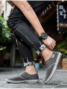 Close-up of grey suede casual shoes with unique white woven trim on the soles