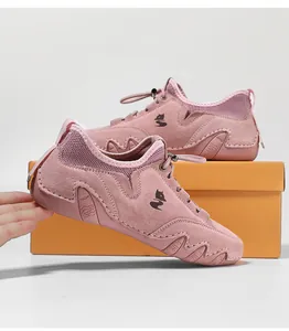 Λεπτομέρεια ροζ σουέτ sneakers με μαύρο λογότυπο αλεπούς και χειροποίητες κυματιστές ραφές