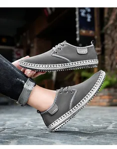 Detail of grey suede casual shoes featuring unique black and white woven midsole trim