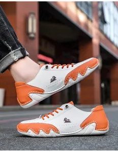Détail de baskets bicolores blanc et orange avec texture cuir et semelle ondulée