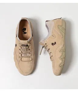 Λεπτομέρεια από χακί σουέτ sneakers με ελαστικά κορδόνια και αντιολισθητική σόλα