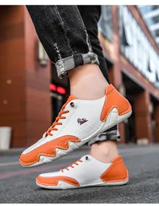 Gros plan de baskets de plein air basses en blanc et orange avec semelle ondulée