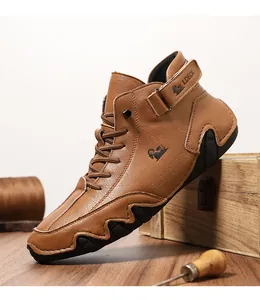 Detail of tan leather high-top boots featuring a velcro strap and rugged black sole