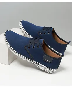 Detailed view of navy blue suede casual shoe with white whipstitch decorative seams