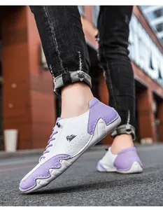 Gros plan de baskets en patchwork blanc et violet avec logo embossé et semelle en caoutchouc