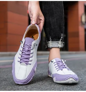 Détail de chaussures décontractées en cuir violet et blanc avec coutures et semelle gomme