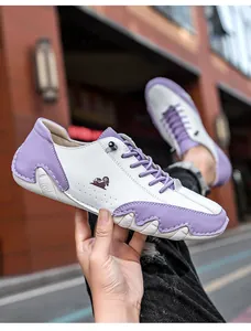 Détail de la chaussure décontractée bicolore avec accents en cuir violet et coutures