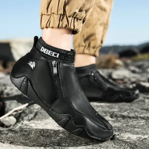 Détail de la bottine en cuir noir avec fermeture éclair latérale et logo tête de bélier