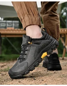 Dettaglio di scarpe da trekking in pelle con spessa suola in gomma antiscivolo su ghiaia