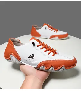 Détail de chaussures décontractées bicolores avec lacets orange et logo mouton sur le côté