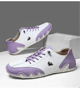 Détail de baskets décontractées bicolores avec logo de chèvre et perforations latérales