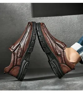 Detail van donkerbruine leren outdoorschoenen met dikke slipvaste rubberen zolen en naden