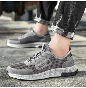 Side view of men's gray mesh sneakers with leather suede trim on a stylish outdoor path