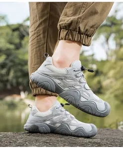 Detail von grauen Outdoor-Lederschuhen mit Mesh und Schnell-Schnürsystem auf Felsen