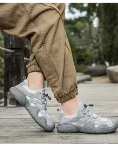 Graue Outdoor-Wanderschuhe aus Leder mit Schnellschnürsystem auf einem Holzsteg