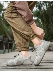 Outdoor-Ledersneaker mit atmungsaktivem Mesh und Schnürsystem am Fuß getragen