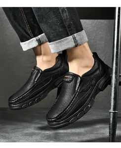 Detail van heren instapschoenen van zwart leer met dikke zool en sportlogo