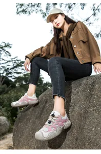 Detail von rosa-weißen Outdoor-Schuhen aus Leder mit Schnellschnürsystem und dicker Antirutschsohle