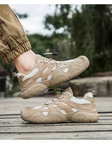 Detailansicht khakifarbener Outdoor-Wanderschuhe mit Zehenschutz auf einer Holzterrasse