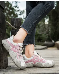 Nahaufnahme der rosa Wildleder-Sneaker mit dicker Gummisohle auf einem Holzsteg