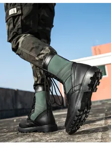 Detail von taktischen Leder-Stiefeln mit Gummisohle und militärischer Tarnhose für Herren