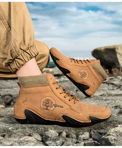 Detalle de botas Chelsea de cuero sintético marrón con cuello de punto y logotipo