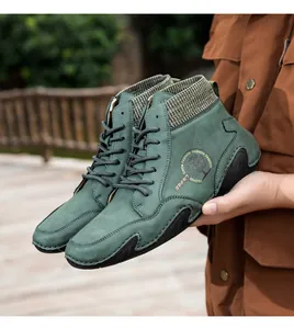 Detalle de botines Chelsea de ante verde oscuro con cuello de punto y logotipo