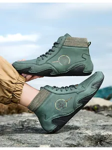 Detalle de zapato de montaña alto con cuero mate, cuello de punto y suela de goma ondulada
