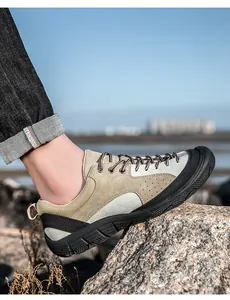 Detail of khaki hiking shoe with suede upper and rugged rubber sole on rocky terrain