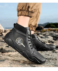 Detalle del botín Chelsea de cuero negro con textura granulada y cuello de punto acanalado