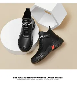 Close-up of black leather kids' martin boots with crown logo and orange sole accents