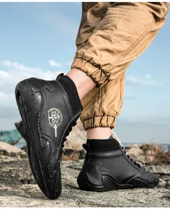 Detalle de zapatillas altas de cuero negro con cuello de punto y logotipo dorado de moda