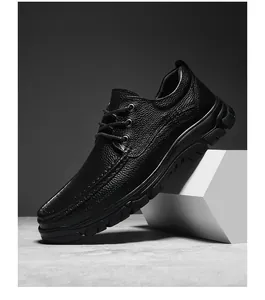 Vue latérale de chaussure en cuir noir avec texture grainée et semelle épaisse en gomme