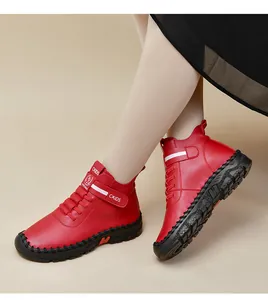 Detailed close-up of red leather high-top boots featuring bold stitching and velcro strap