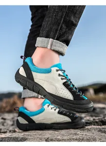 Detail of grey suede hiking shoes with blue mesh and rugged rubber soles for outdoors