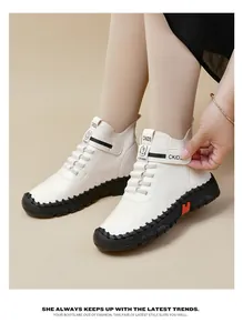 Detail of off-white high-top boots featuring a thick black sole and velcro strap