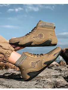 Detalle de bota alta de cuero marrón con cuello de punto y logo sobre terreno rocoso
