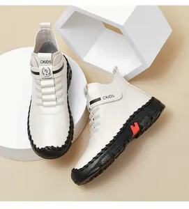 Close-up of cream leather high-top boot with black velcro straps and red sole details