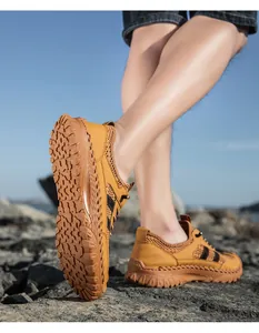 Detail van ademende gele mesh sneakers met antislip rubberen zolen op rotsachtig terrein