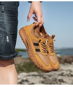 Detail van handgestikt leer en ademend mesh op kaki heren outdoor sportschoenen voor heren