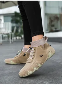 Outdoor-Aufnahme von High-Top-Sneakern aus khakifarbenem Wildleder mit markanter Wellensohle