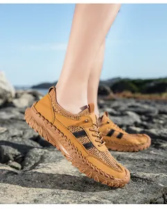 Detailopname van bruine ademende mesh en leren sneakers op rotsachtig terrein