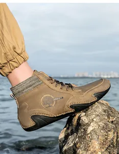 Detalle de botas Chelsea de nubuck marrón con cuello de punto y logotipo en relieve
