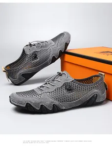 Detail van grijze ademende mesh sportschoenen met suède overlays en oranje schoenendoos